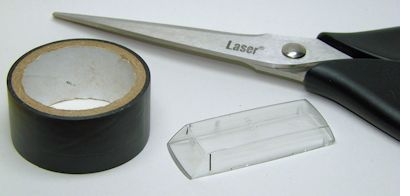 Verglasung mit Fensterholmen, eine Rolle schwarzes Isolierband sowie eine Schere