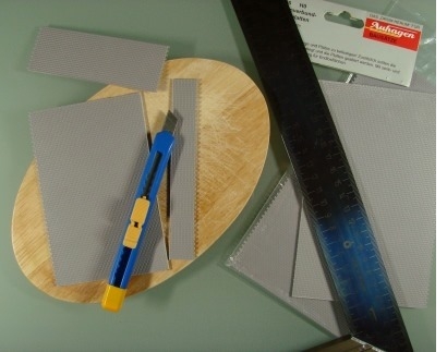 Zuschneiden der Pflasterplatten mit Bastelmesser und Stahllineal